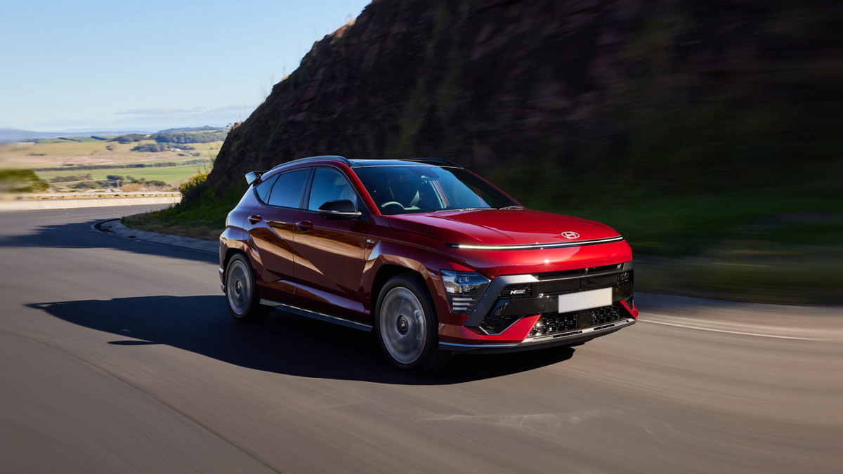 A red Hyundai Kona on a coastal road, sold at Dalton Hyundai National City